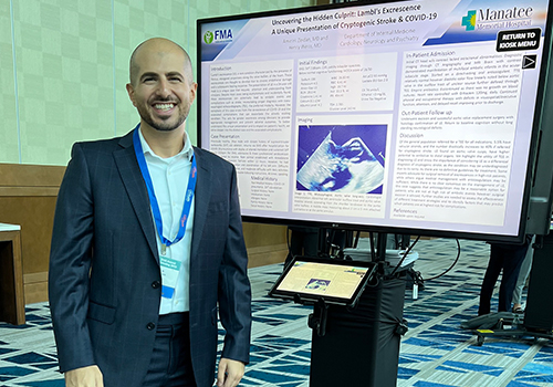 Amir H. Zeidan, MD stands with his winning poster