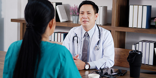 Two medical personnel talk to each other