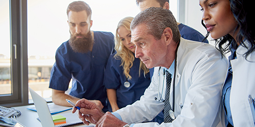 Physician team looking at a computer