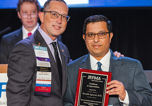 Dr. Lenchus presents an award to Dr. Agrawal
