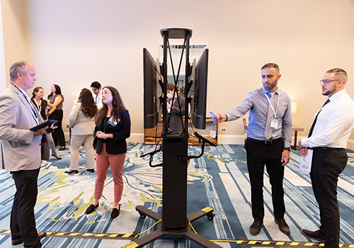 Image of two different groups of students presenting their posters to judges