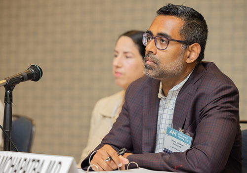 Two FMA members sit at a desk for the Annual Meeting Reference Committees