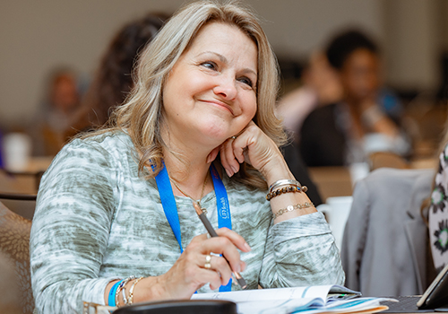 Female physician smiles while being taught.