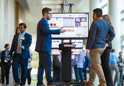 A student presents his work at the Poster Symposium