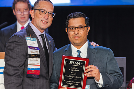 Dr. Agrawal receives an award from Dr. Lenchus at the 2022 FMA Annual Meeting