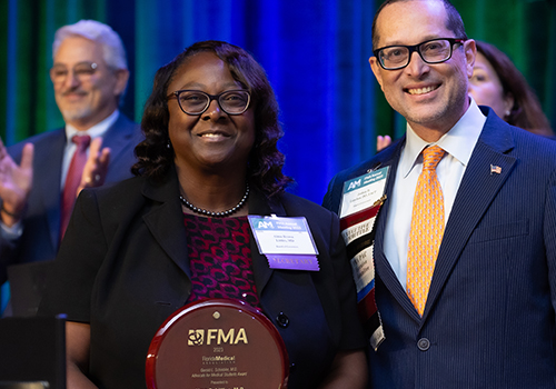 Alma Littles, MD receives an award from Joshua Lenchus, DO